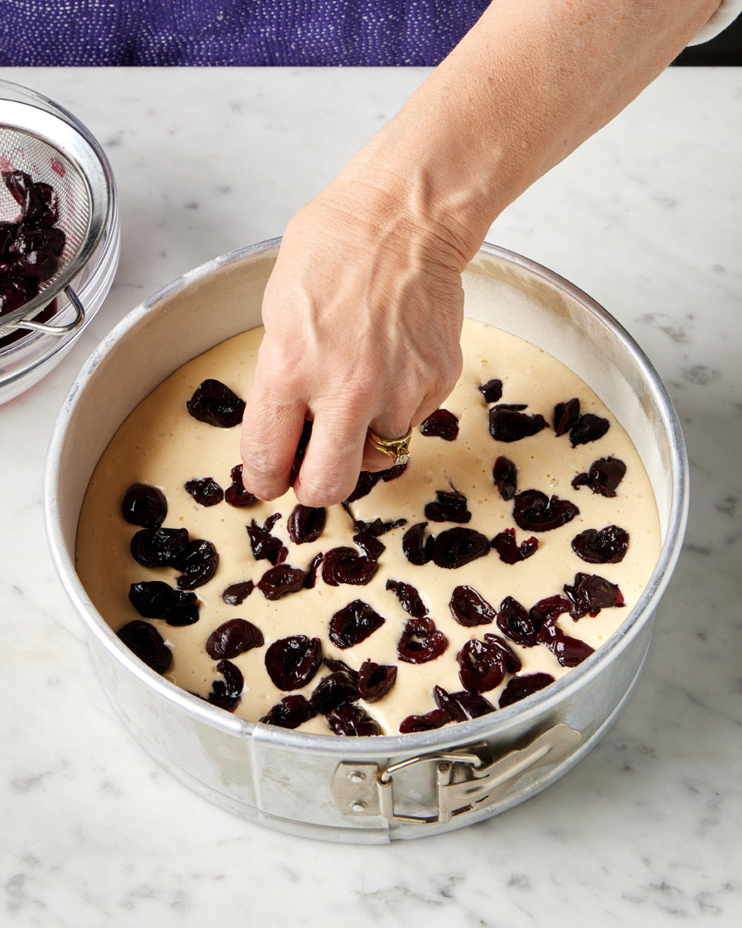 8. Scatter the cherries evenly over the batter; discard the juices or reserve for another use. Bake until the cake is golden brown and the edges spring back when gently pressed.