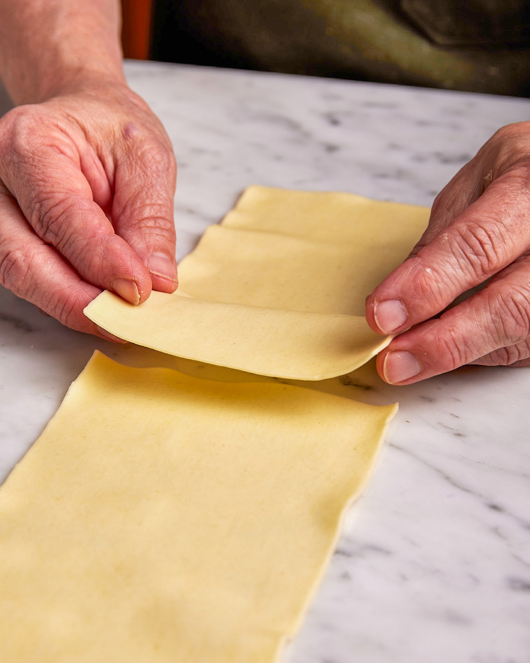1. Lay down 1 lasagna noodle with a short end facing you. Layer it with a second noodle, creating a ½-inch overlap. Lightly press the overlap to seal.