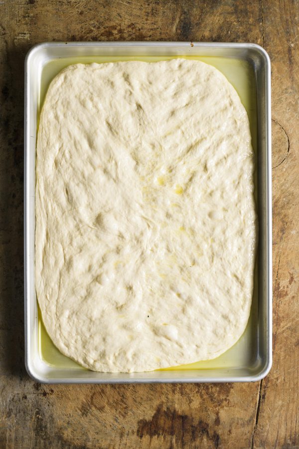 2. Using well-oiled fingers, push the dough from the center toward the corners—be gentle.